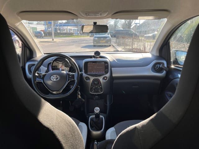 Interieur van de grijze Toyota Aygo 2017 met touchscreen en handgeschakelde versnellingsbak